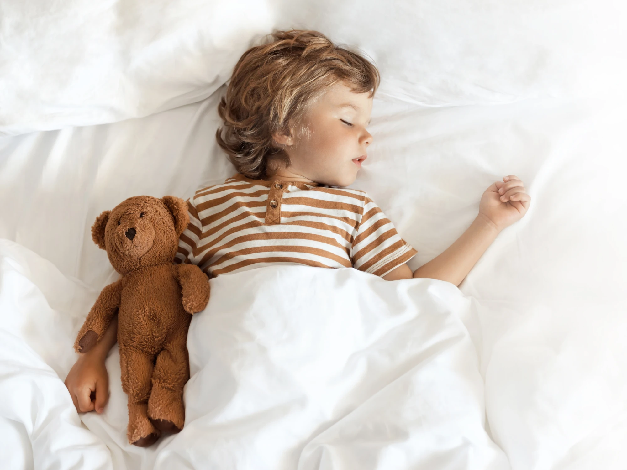 Junge schläft mit Teddybär